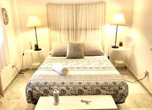 a bedroom with a bed with two lamps and two tables at Budget & Lovely Rooms Las Setas in Seville