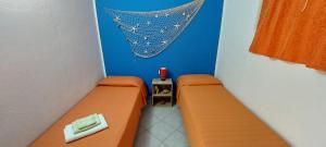een kamer met twee bedden en een net aan de muur bij Casa Vacanze Laura in Tortolì