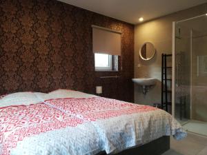 1 dormitorio con cama roja y blanca y lavamanos en Maison La Lande, en Waimes