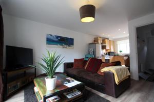 a living room with a couch and a tv at Lymm House in Lymm