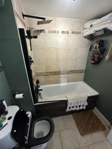 a bathroom with a tub and a toilet and a sink at Converted church in Beckenham