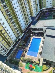 an overhead view of two tall buildings with a swimming pool at Affordable staycation @Mesaverte Residences cdo in Cagayan de Oro