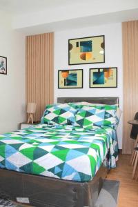 a bedroom with a bed with a blue and green at Affordable staycation @Mesaverte Residences cdo in Cagayan de Oro