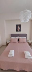 een groot roze bed met twee handdoeken erop bij Cristina‘s Place in Heraklion