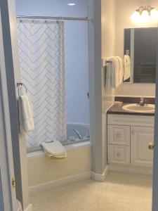 łazienka z umywalką i prysznicem z oknem w obiekcie Acadia Village Resort w mieście Ellsworth