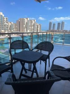 patio ze stołem i krzesłami na balkonie w obiekcie Alamein downtown north cost w mieście El Alamein
