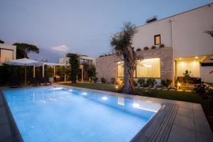 a swimming pool in front of a house at SanPietro Vacation Rentals in Durrës