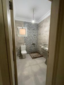La salle de bains est pourvue de toilettes et d'un lavabo. dans l'établissement Alamein downtown north cost, à El Alamein