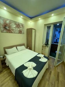 Un dormitorio con una gran cama blanca con dos flores. en Central Elegance Estate, en Belgrado