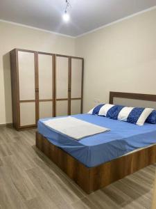 - une chambre dotée d'un lit avec des draps bleus et blancs dans l'établissement Alamein downtown north cost, à El Alamein