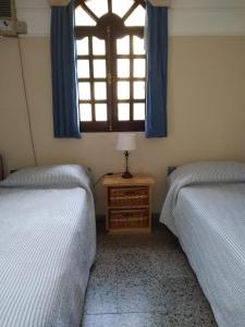 a bedroom with two twin beds and a window at San Antonio in Federación +3 photos