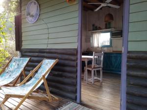 a porch with two chairs and a table on a house at la cabanita pinamar in Pinamar