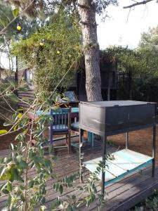 a ping pong table on a deck next to a tree at la cabanita pinamar in Pinamar