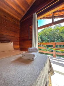 a bedroom with a bed and a large window at Pousada Mata Nativa in Abraão