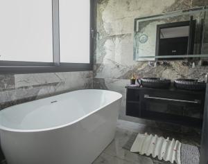 a white bath tub in a bathroom with a stone wall at Dar baby in Marrakesh