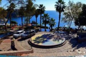un aparcamiento con coches, palmeras y el océano en Fabulous Location Close to Old Town en Antalya