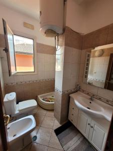 y baño con aseo, lavabo y bañera. en Nice and friendly apartment, en Elbasan