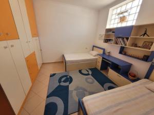 Habitación pequeña con 2 camas y escritorio. en Nice and friendly apartment, en Elbasan