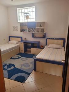 1 dormitorio con 2 camas, escritorio y ventana en Nice and friendly apartment, en Elbasan