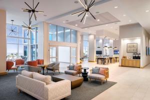 a lobby with chairs and tables and windows at Fairfield by Marriott Inn & Suites Pensacola Beach in Pensacola Beach