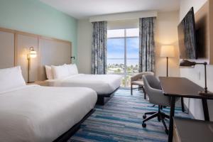 a hotel room with two beds and a desk at Fairfield by Marriott Inn & Suites Pensacola Beach in Pensacola Beach