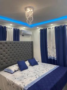 een slaapkamer met een groot bed en blauwe gordijnen bij Residencial Mena, penthouse in Santiago de los Caballeros