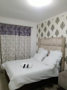 a bedroom with a white bed with a robe on it at Pinto City Motel in Kempton Park