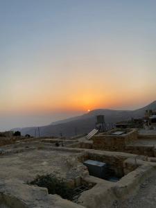 a sunset in the sky with the sun setting in the distance at Dana Moon Hostel in Dana