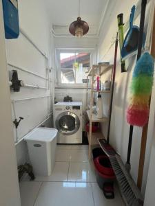 y baño pequeño con aseo y lavadora. en Idyllische Gästehaus im grünen en Altenstadt