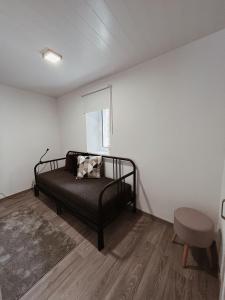 a bedroom with a black bed and a chair at Cantinhos Da Serra e Sopé, Soure in Soure
