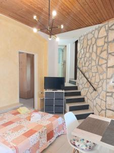 ein Schlafzimmer mit einem Bett und einer Steinmauer in der Unterkunft Apartment Kiwi in Rabac
