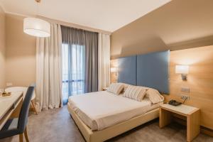 um quarto com uma cama, uma mesa e uma secretária em Hotel Calabona em Alghero