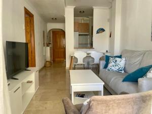 uma sala de estar com um sofá e uma televisão em Apartamento Vive Garrucha em Garrucha