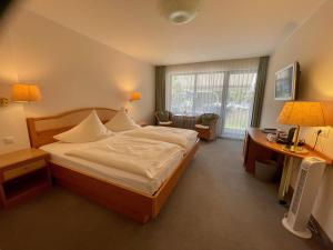 ein Hotelzimmer mit einem großen Bett und einem Schreibtisch in der Unterkunft Der Schützenhof in Bad Neuenahr-Ahrweiler