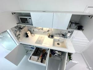 una pequeña cocina con fregadero y microondas en Studio Trip In Paris - Gare de l'Est, en París