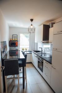a kitchen with white cabinets and a table and a window at Casa Melisa I 61m² I WLAN in Witten