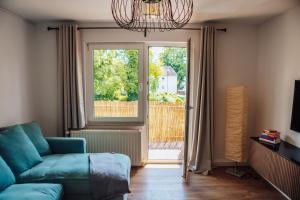 a living room with a blue couch and a window at Casa Melisa I 61m² I WLAN in Witten
