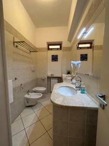 a large bathroom with a sink and a toilet at Arcobaleno Tropea centro in Tropea