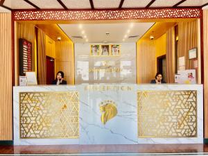 two women standing behind a counter in a hotel lobby at Golden Tulip Deira Hotel in Dubai