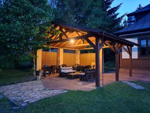 eine hölzerne Pergola mit einem Tisch und Stühlen auf einer Terrasse in der Unterkunft Willa Milonga in Sandomierz