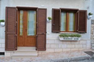 una casa con due finestre e una porta in legno di Marghegio' house a Ceglie Messapica