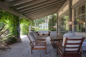 eine Veranda mit Stühlen, einem Tisch und Fenstern in der Unterkunft Hotel Iturregi in Getaria