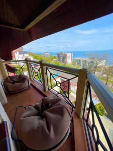 Un balcón con sillas y vistas al océano. en Villa-Sofia Mini-hotel en Odesa