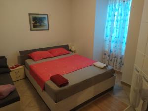 a bedroom with a large bed with red pillows at Aquamare Apartment in Rijeka