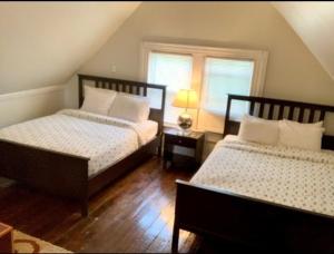 een slaapkamer met 2 bedden en een raam bij The House Hotels - Ridgewood Upper in Lakewood