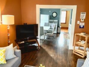 een woonkamer met een bank en een flatscreen-tv bij The House Hotels - Ridgewood Upper in Lakewood