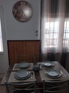 a dining room table with a clock on the wall at Villa Απέραντο Γαλάζιο in Samothraki