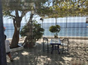 a table and chairs with a view of the water at Villa Απέραντο Γαλάζιο in Samothraki