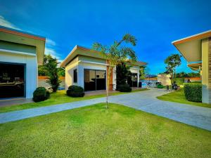 a house with a palm tree in the yard at The Memories Hill Phuket in Thalang