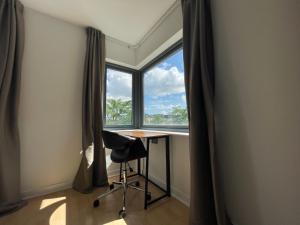 Zimmer mit einem Schreibtisch und einem Fenster mit einem Stuhl in der Unterkunft Quiet Luxe Home with GYM and Free Parking in Thamesmead